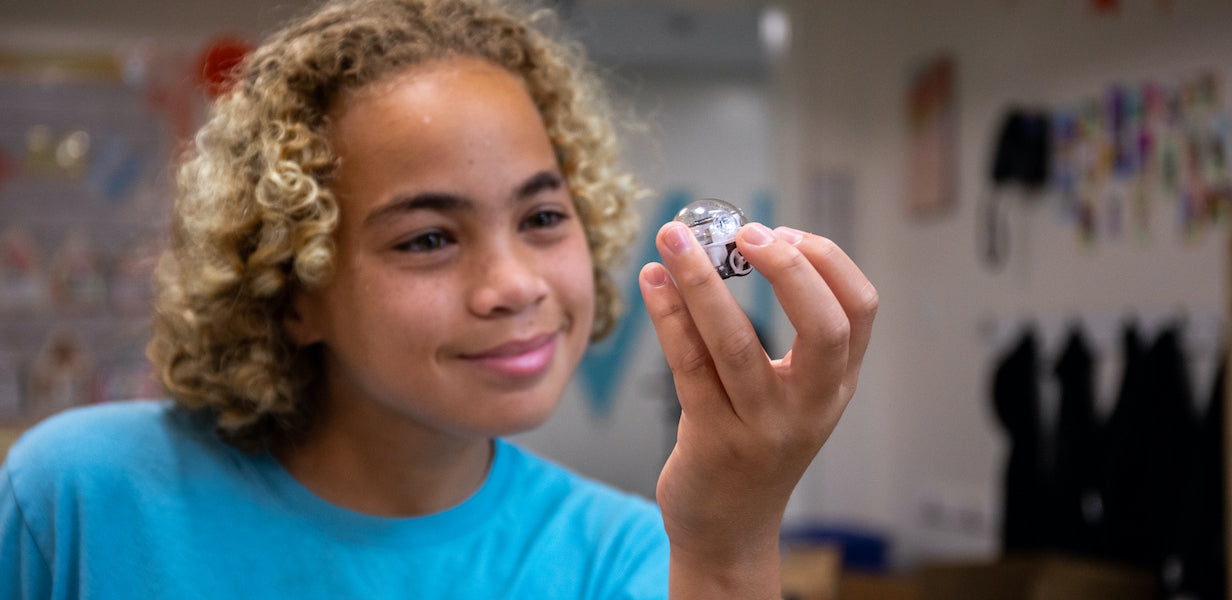 National Robotics Week 2024: smiling student holding Evo programmable robot