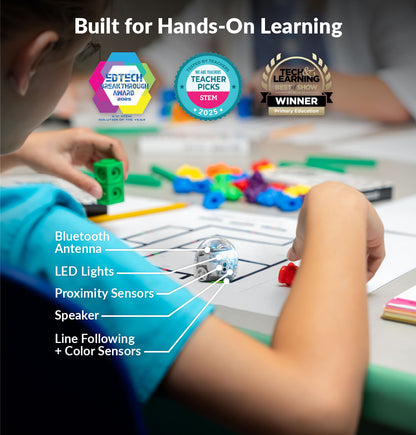 Groups of elementary students collaborating on a hands-on robotics activity with Ozobot Evo robots in a large classroom