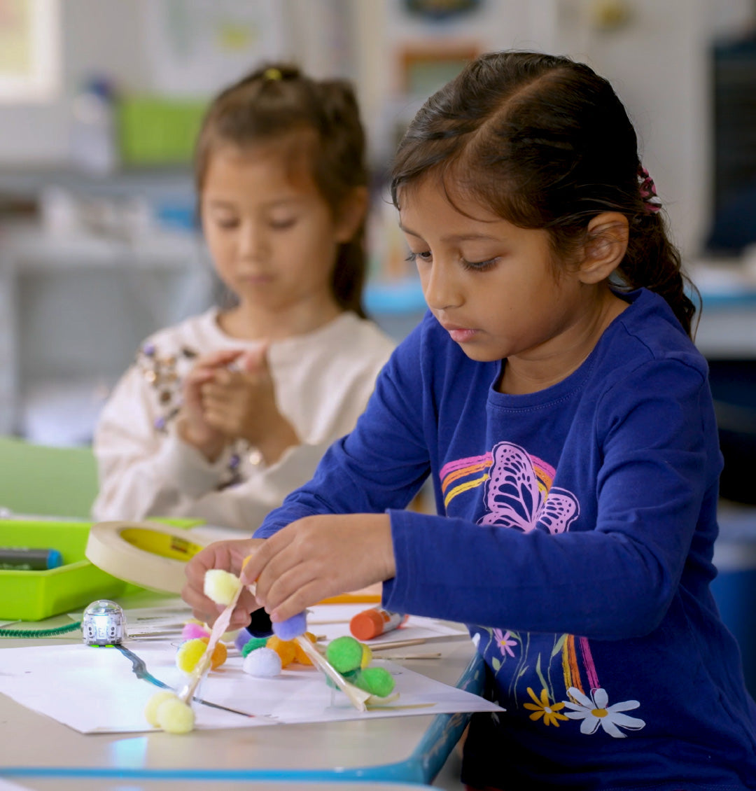 Elementary school students collaborating on a hands-on Ozobot STEM activity, developing creativity, teamwork, and problem-solving skills.